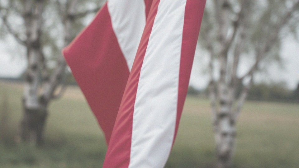 Co symbolizuje biały pas na fladze Łotwy?